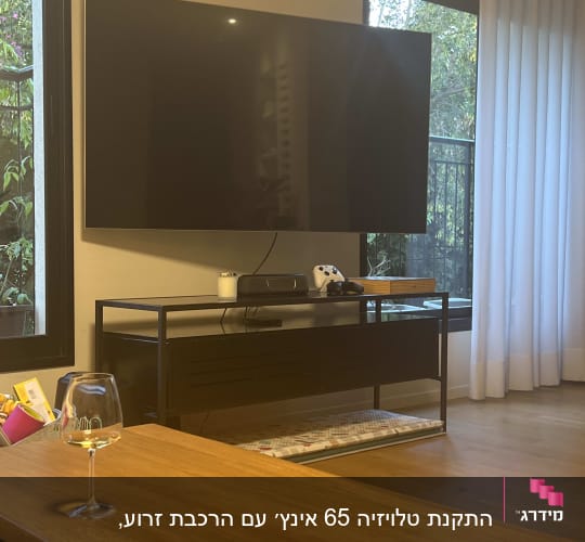 טלוויזיה תלויה על הקיר עם כבלים חשמליים
